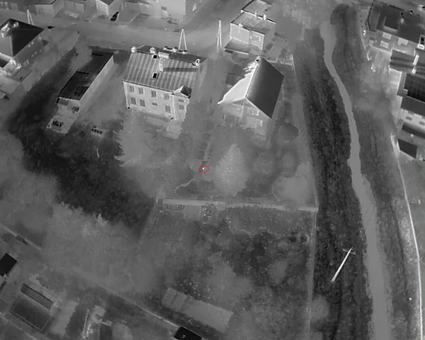 Szeroki widok termowizyjny ogrodu i domu z zaznaczonym punktem